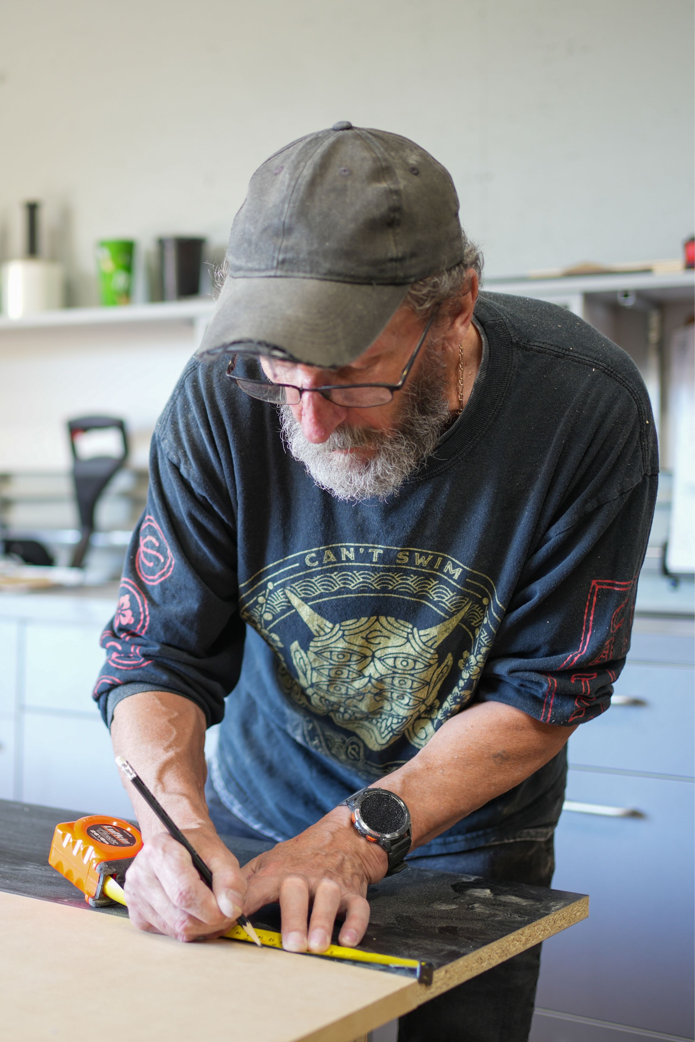Skilled craftsman at Goosen Inc. measuring and cutting wood for custom millwork project