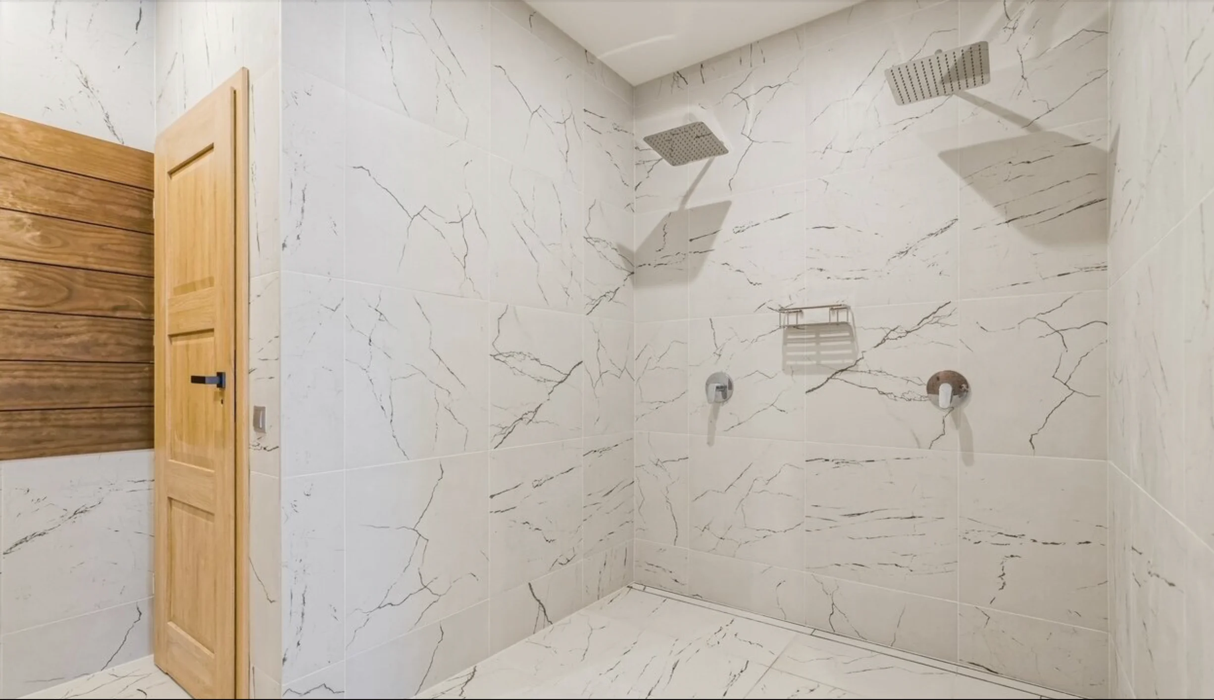 2 showers in a modern marble bathroom.