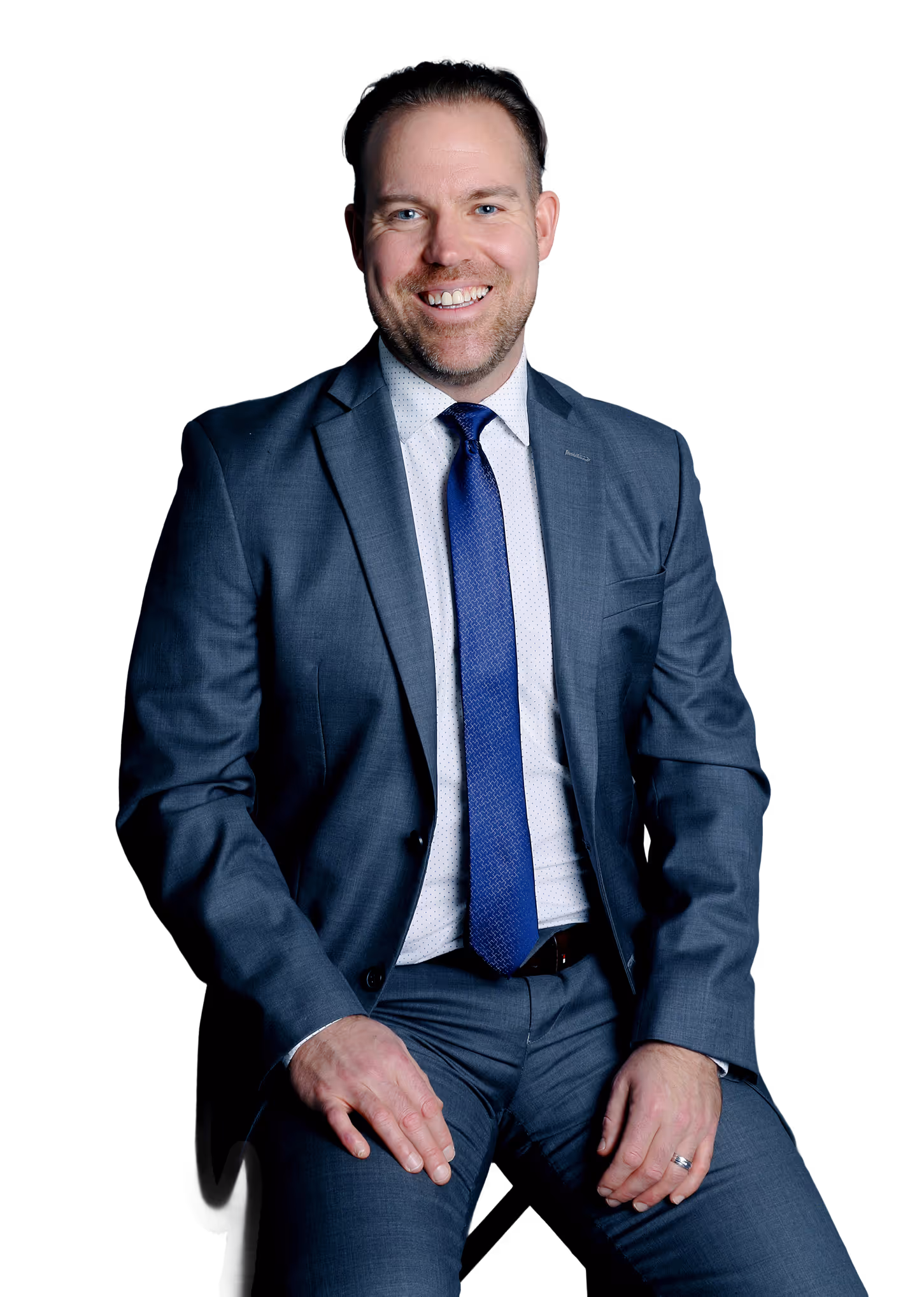 Confident businessman in a blue suit and tie sits calmly in office.