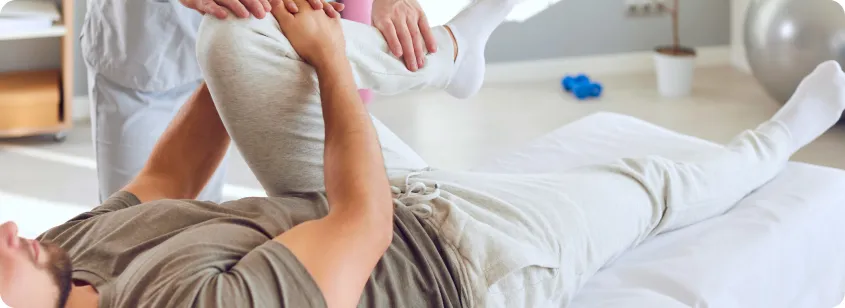 Doctor helping man stretch leg