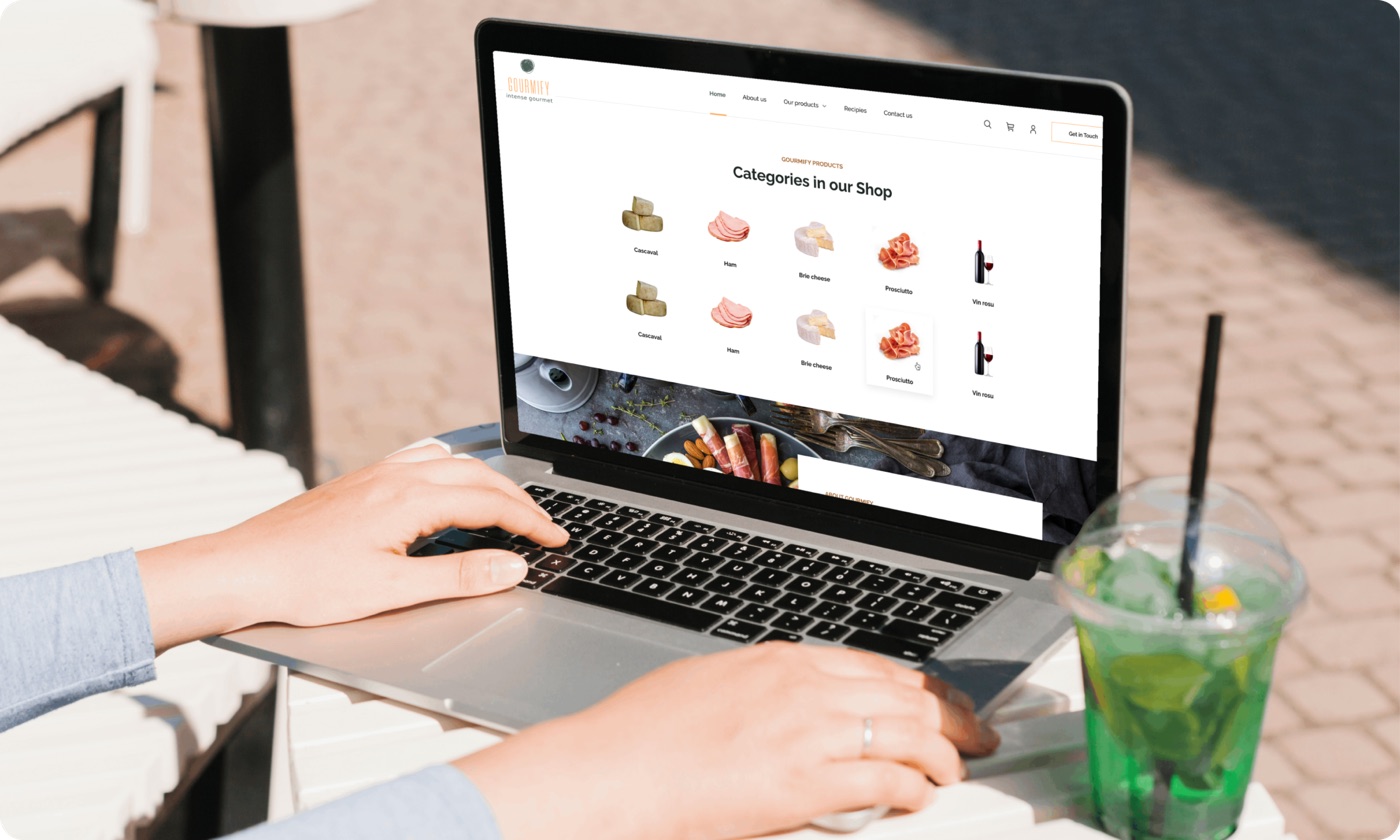 Customer browsing the Gourmify.ro shop on a laptop at a cafe table