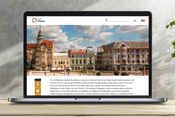 VisitOradea.com homepage on a laptop showing Oradea city center