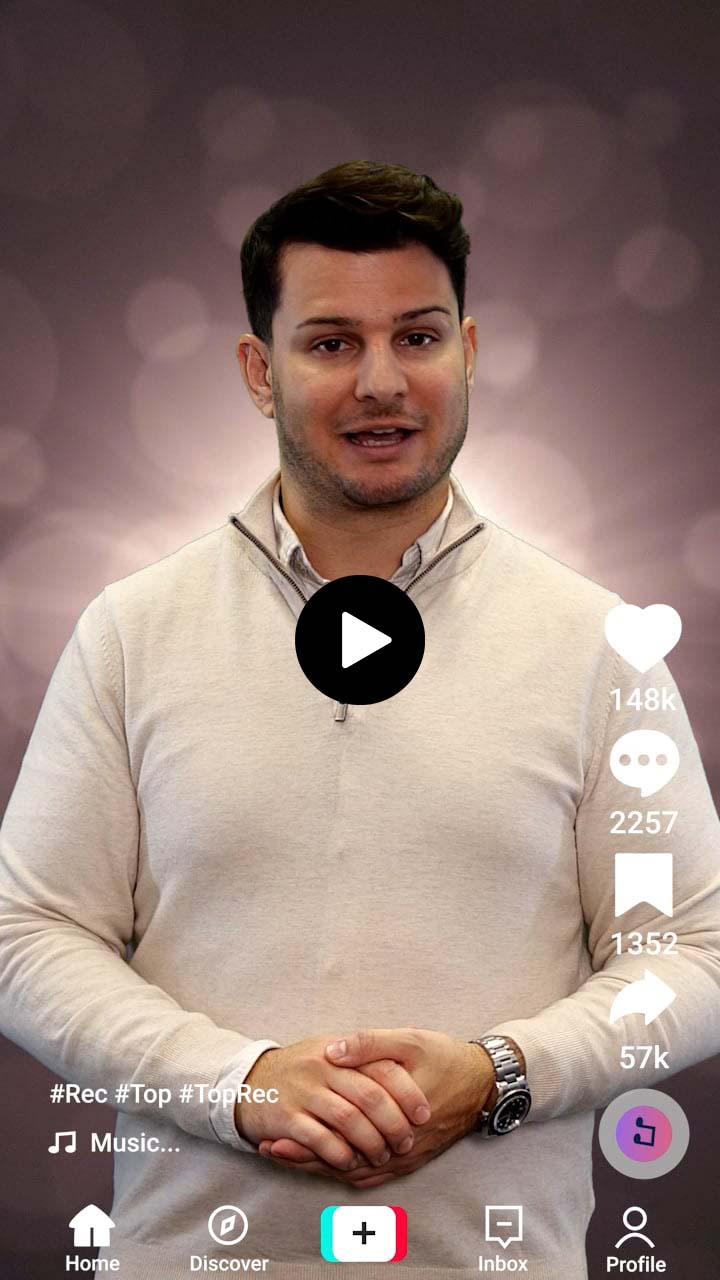 Man with short dark hair wearing a beige quarter-zip sweater, speaking with hands clasped in front of a blurred grayish background, TikTok interface visible.