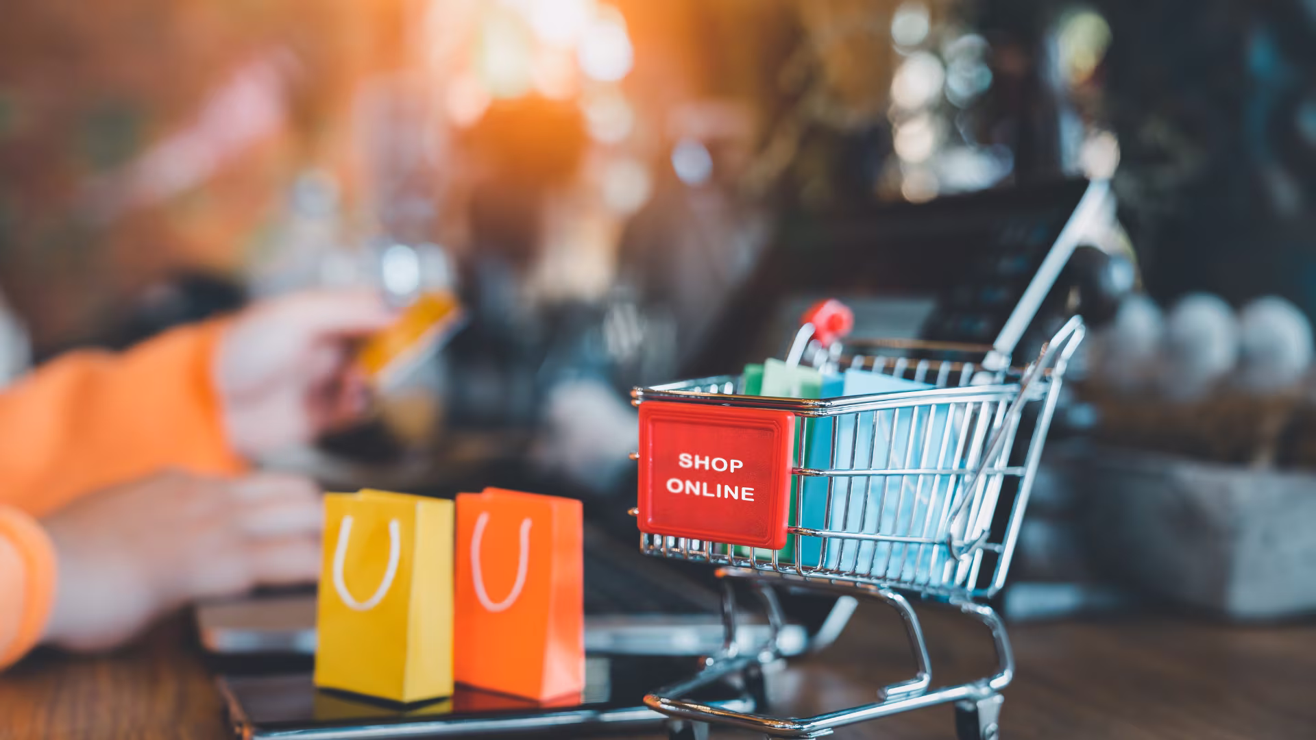 small shopping cart next to a laptop 