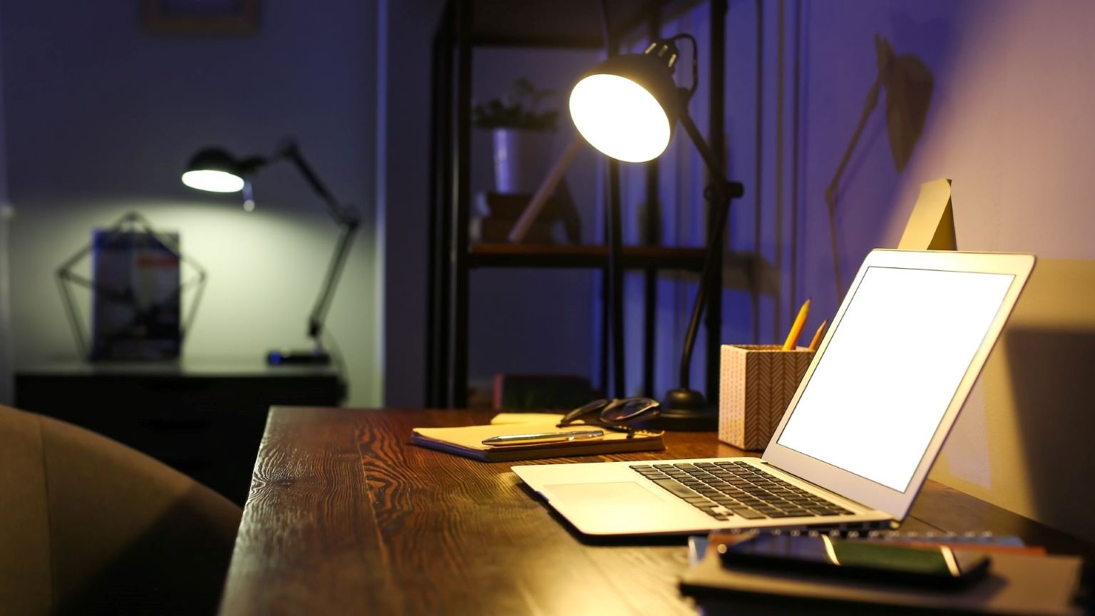 Laptop on a desk in a dark room
