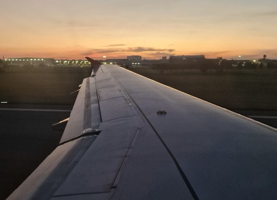 Picture of a plane landing at Bali Airport at dawn. Illustration