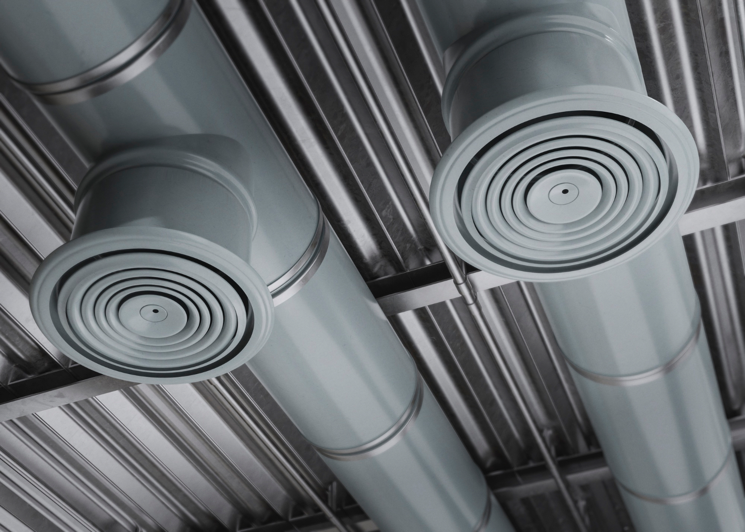 Industrial ventilation pipes with circular vents in metallic gray