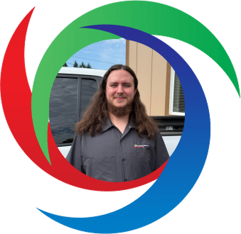 A person in a gray shirt standing in front of a building and circular logo