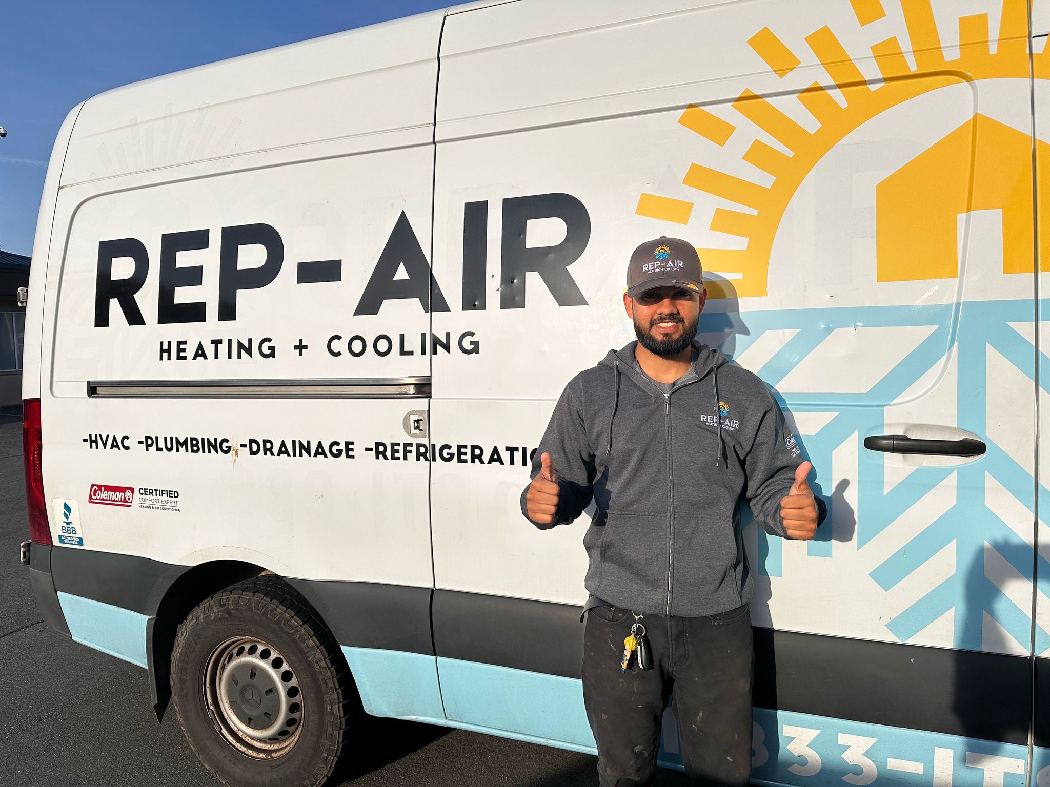 Rep-Air technician gives thumbs up next to company service van