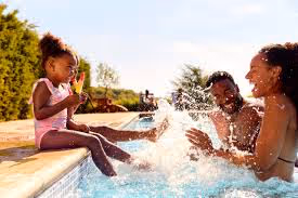 Joyful family splashing and playing together in a sunny outdoor pool