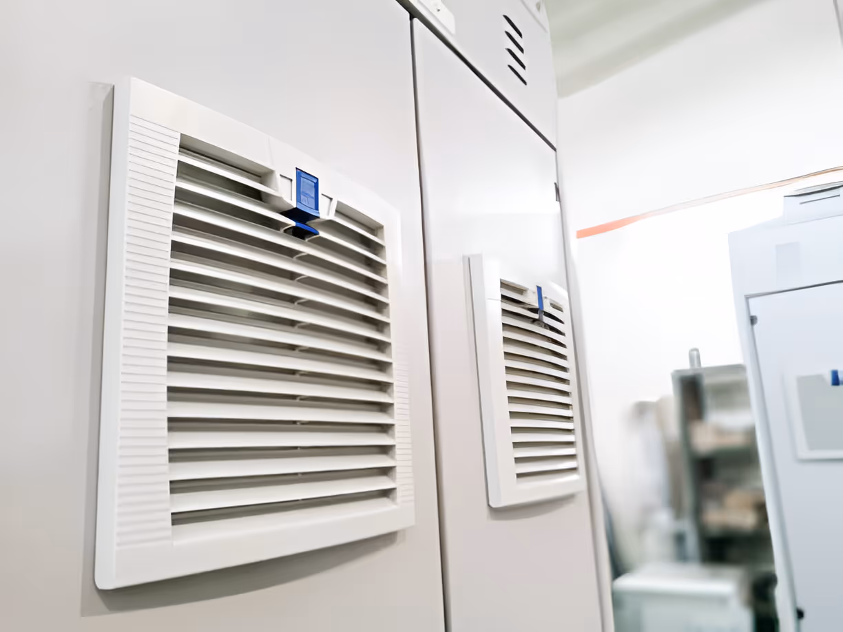 White air vents with blue tags on clean, modern wall