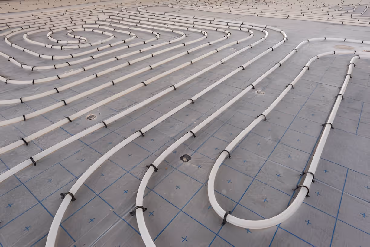 Radiant floor heating pipes installed on gridded concrete subfloor
