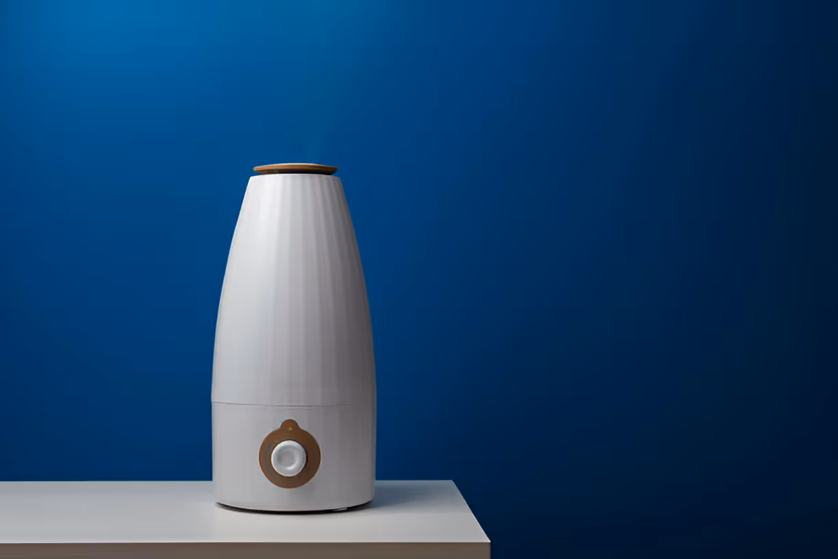 White air humidifier with wooden top against blue gradient background