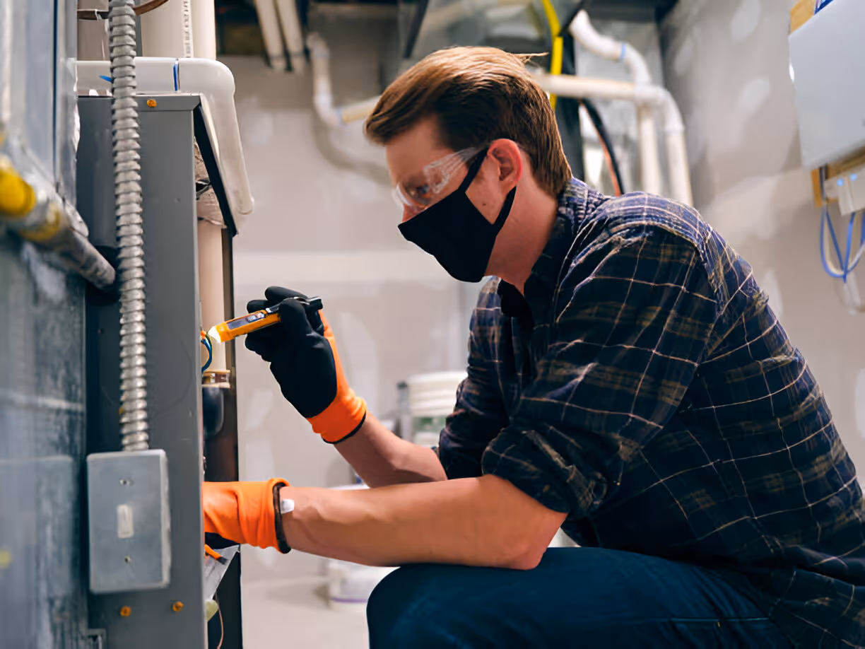Technician in safety gear inspects equipment in industrial facility