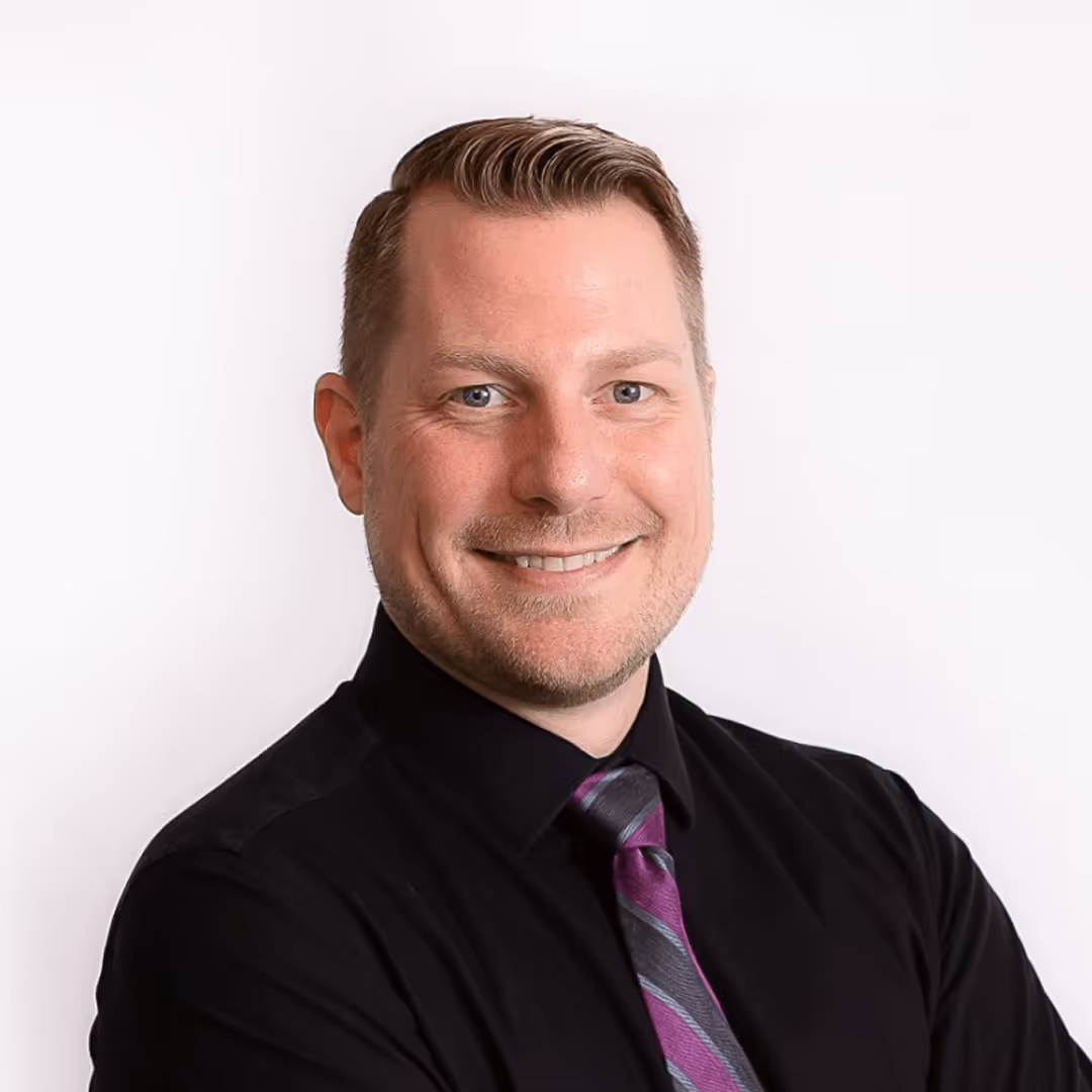 Smiling professional in black shirt and purple striped tie