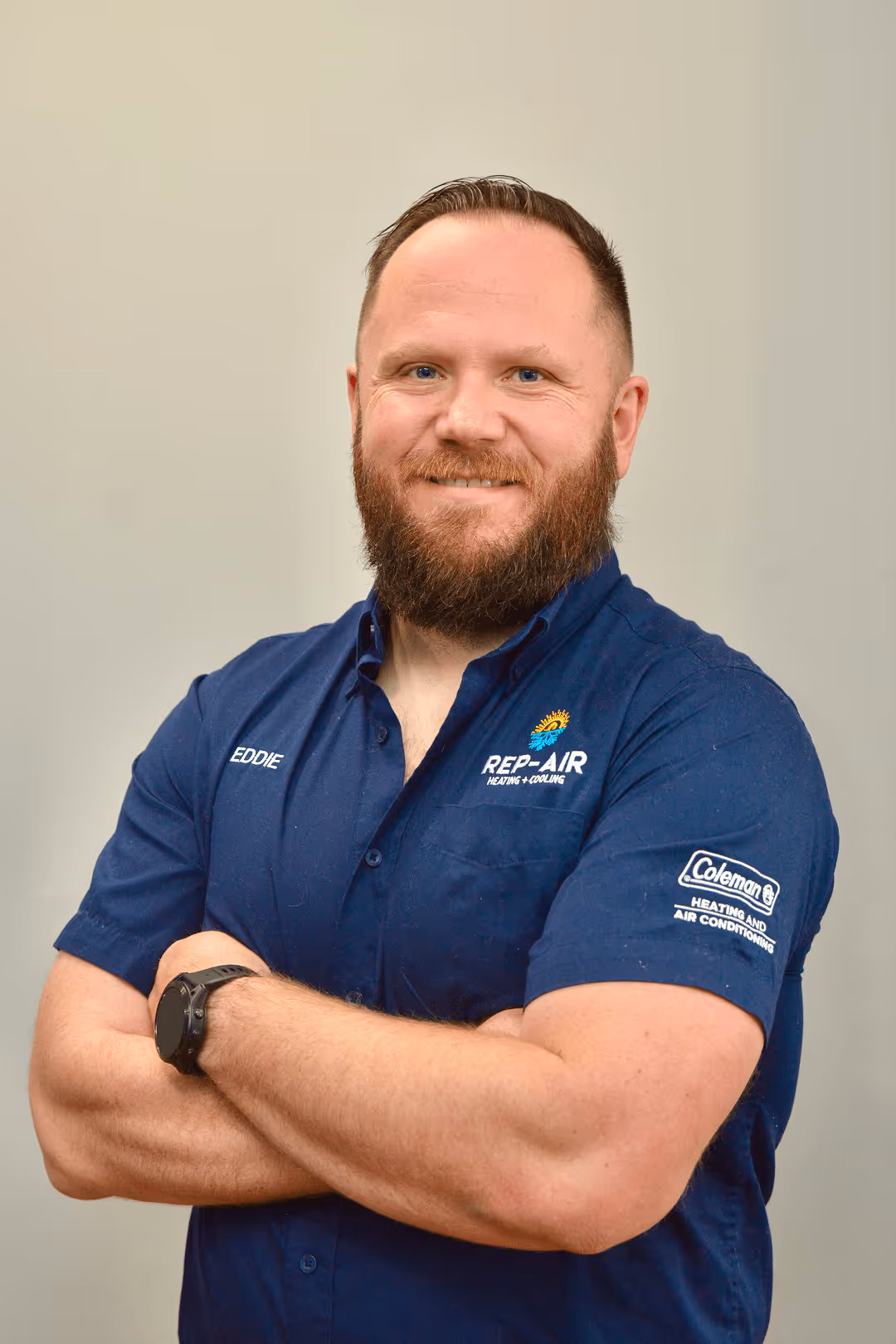 Smiling technician in blue Rep-Air uniform with crossed arms