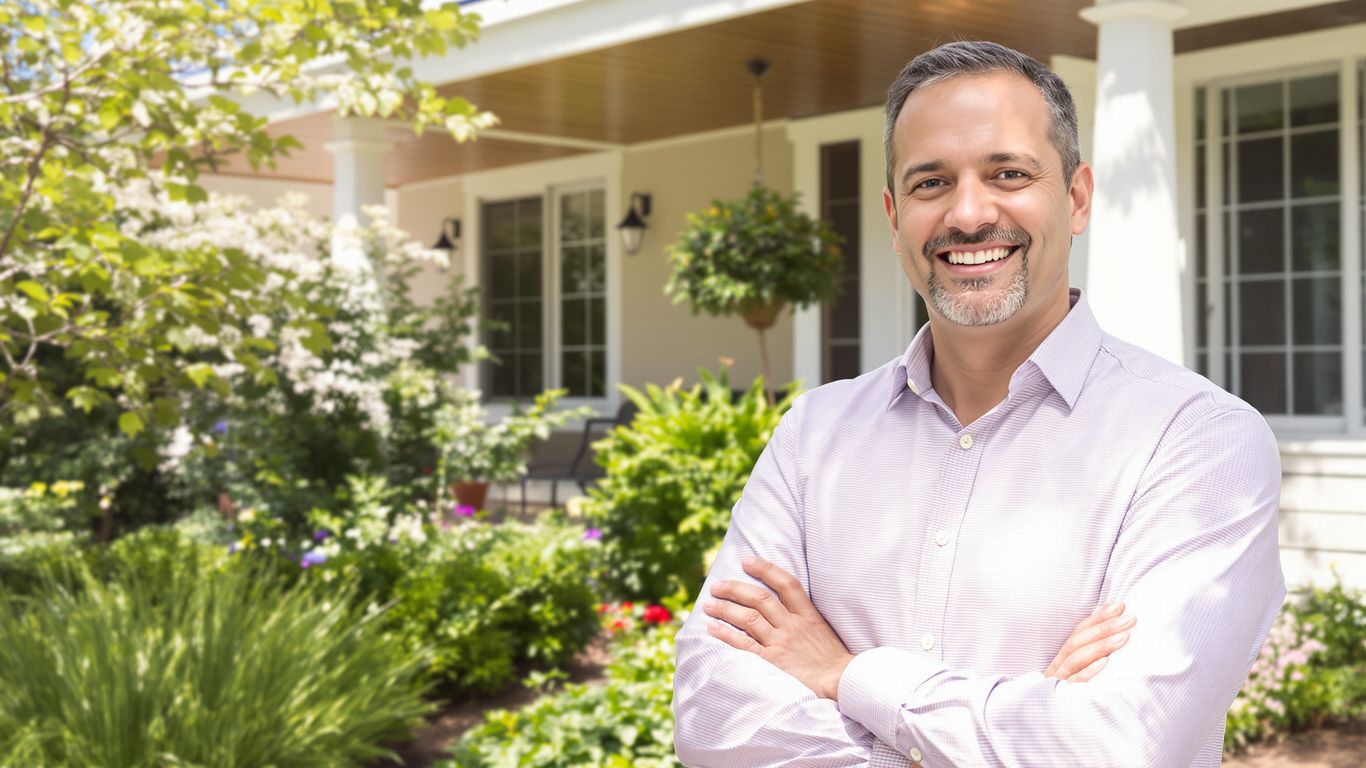 Realtor smiling in front of a modern house.