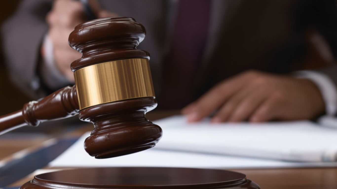 Gavel striking desk in office setting.
