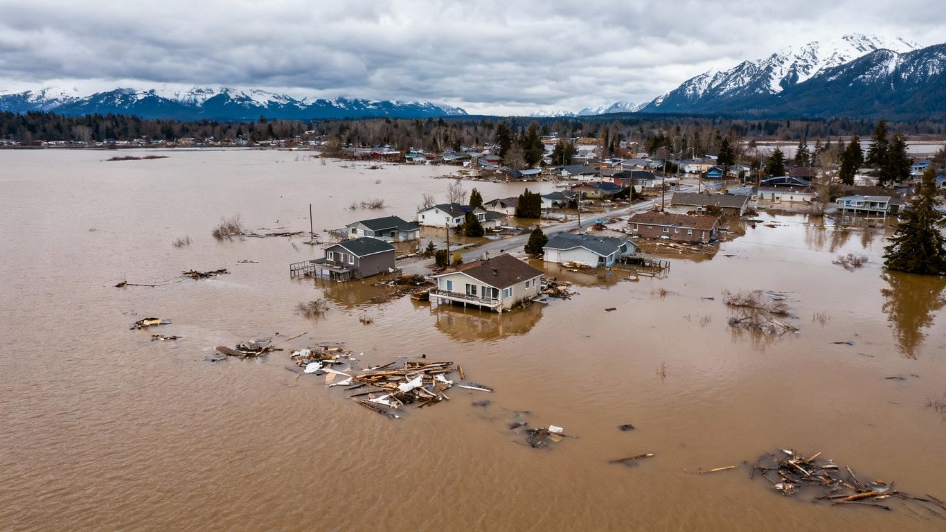 Flooded British Columbia town with submerged houses and debris.