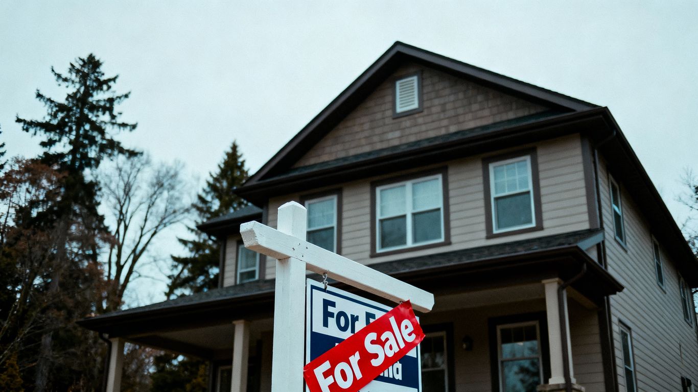 House with a 'Sold' sticker, muted surroundings.