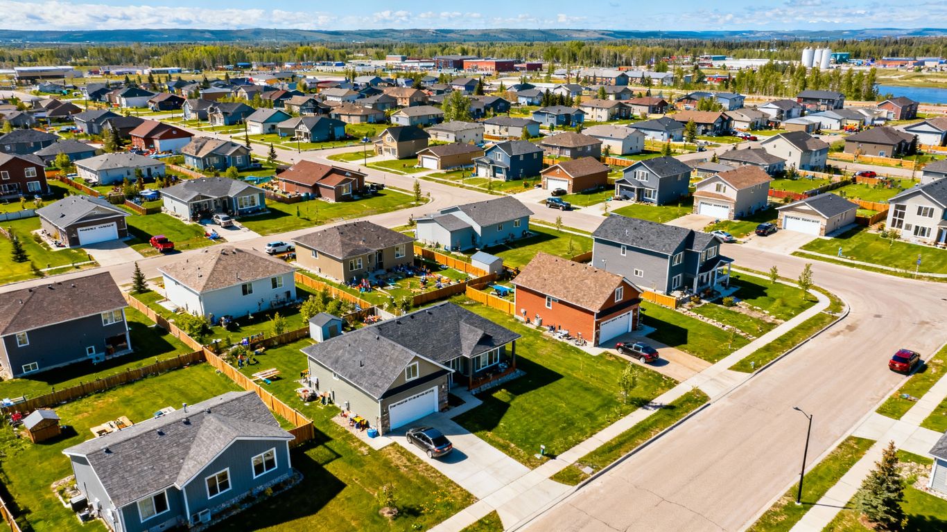 Fort St. John houses with sunny sky and green yards.