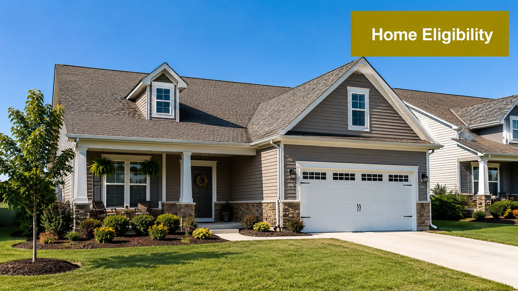 A suburban house with beige siding, a stone foundation, a manicured lawn, and a two-car garage.