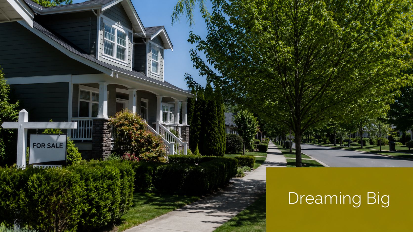 A for sale sign stands in front of a beautiful grey residential house with a green lawn.