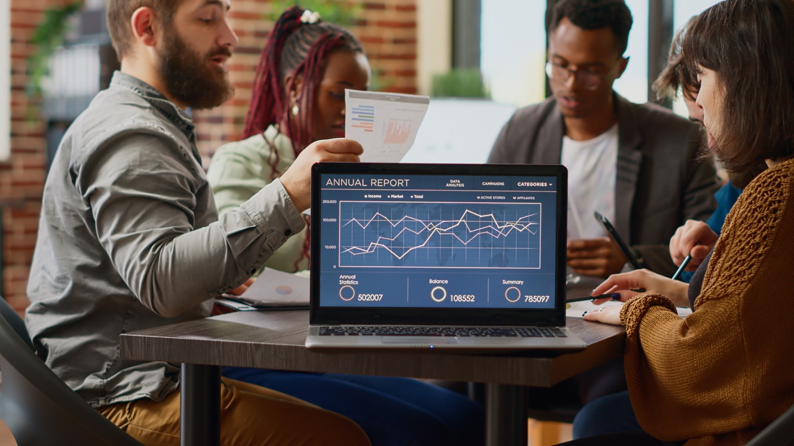 Team in a working session reviewing a live analytics dashboard on a laptop