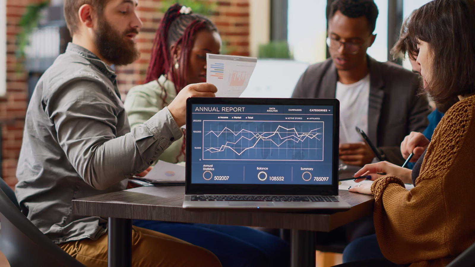 Team in a working session reviewing a live analytics dashboard on a laptop