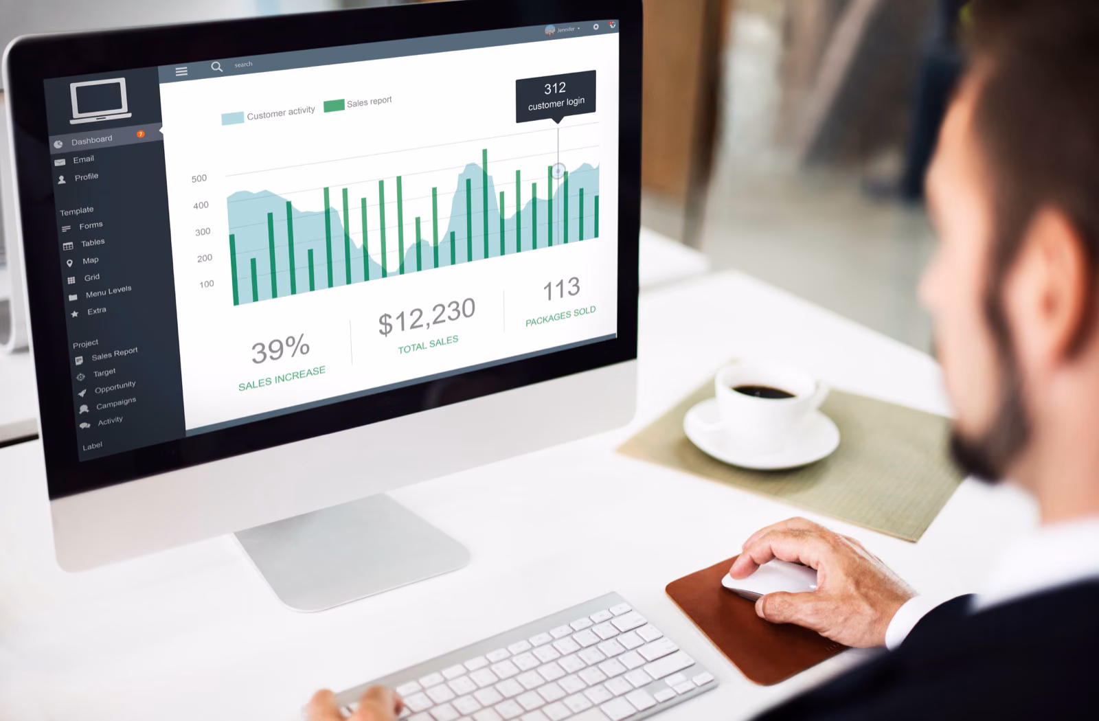 Business professional reviewing a sales analytics dashboard on a desktop monitor
