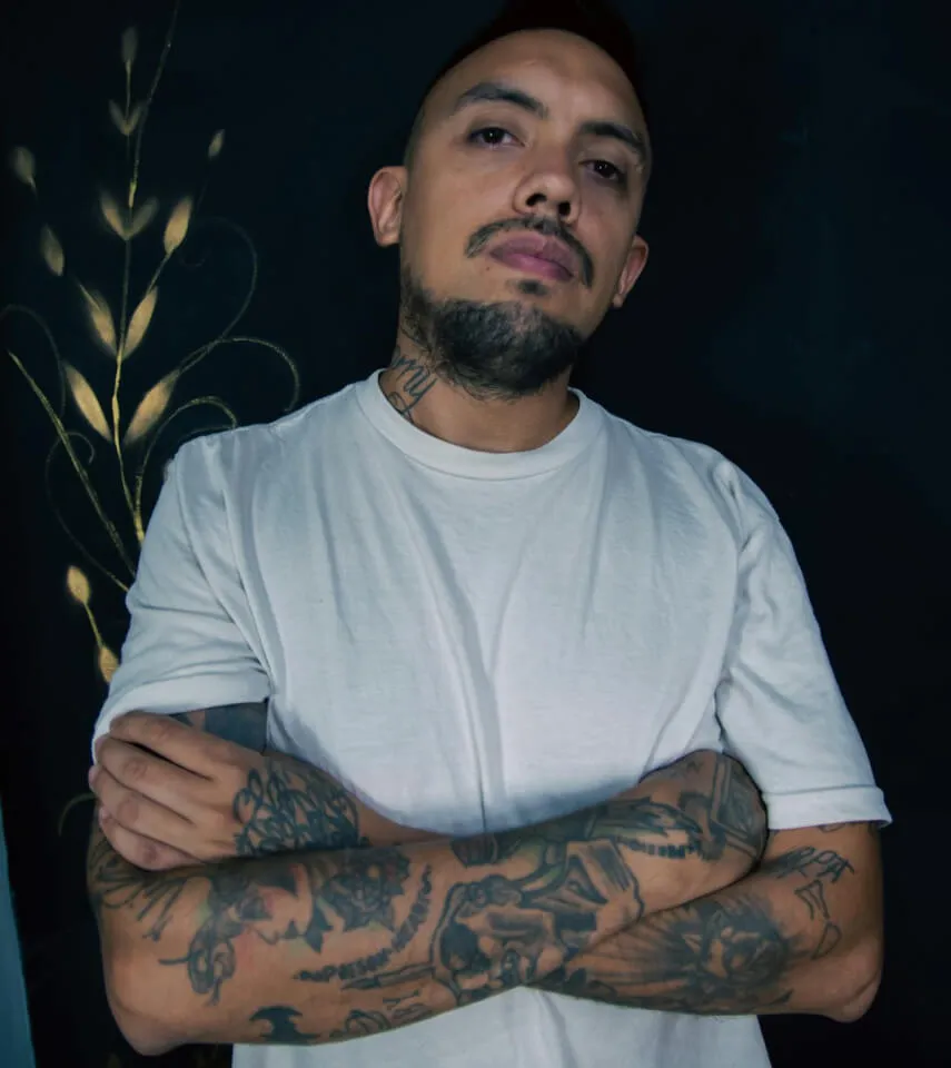 man with tattoos wearing a white t shirt