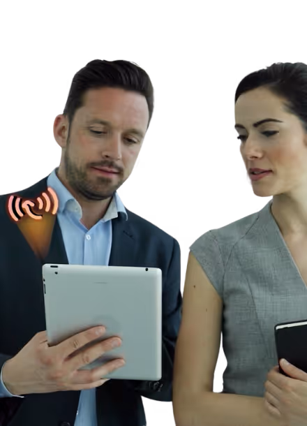 A man in a suit holding a tablet showing a notification icon while a woman in business attire looks on.
