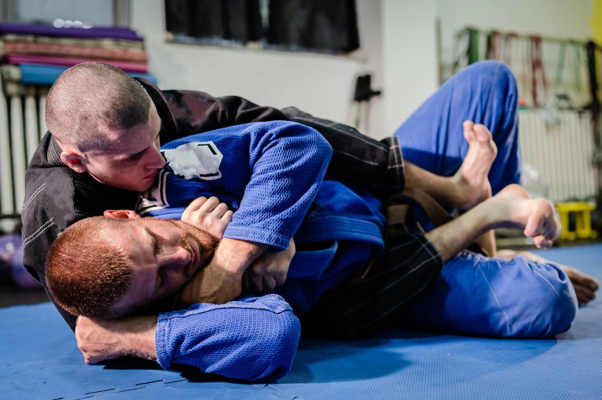 Pratique du jiu-jitsu brésilien à Strasbourg lors d’un entraînement au sol entre deux pratiquants en kimono.