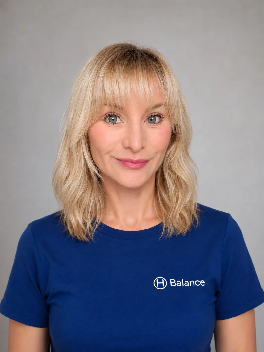 Portrait d'une intervenante de l'équipe H Balance à Strasbourg, en t-shirt bleu de la marque.