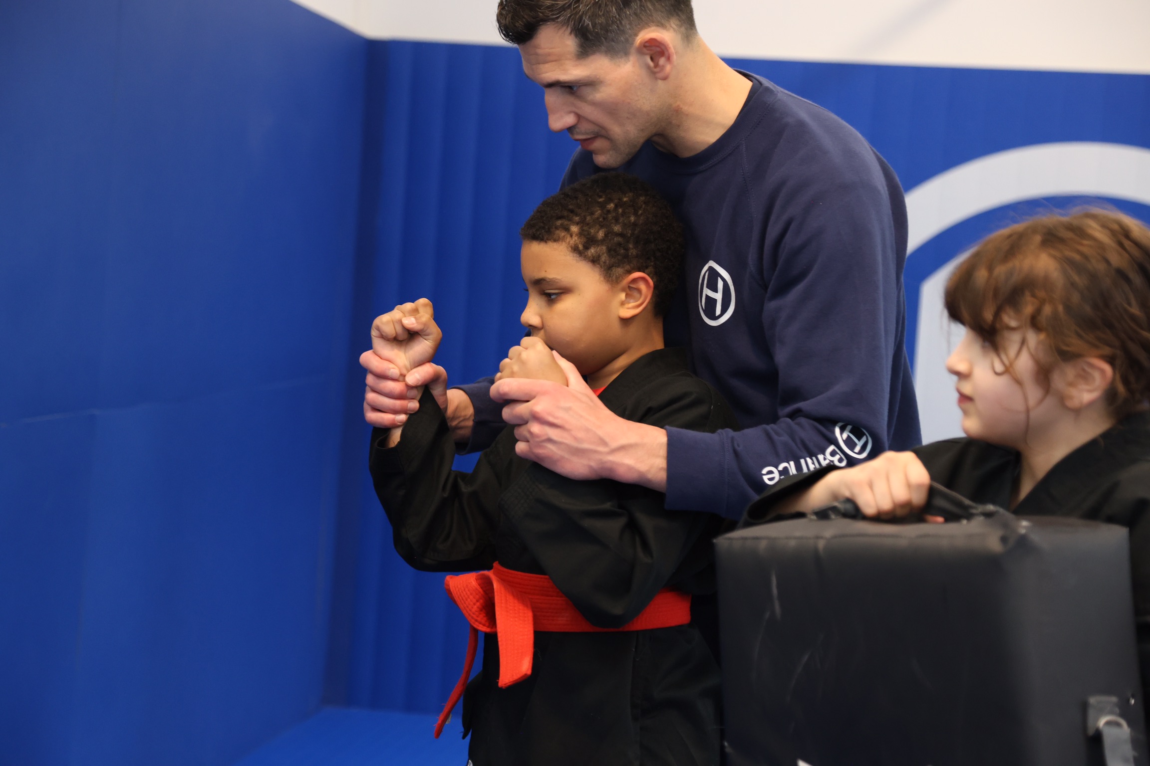 Enfant pratiquant le Kung Fu avec l’accompagnement d’un instructeur chez H Balance Kung Fu Kids à Strasbourg.
