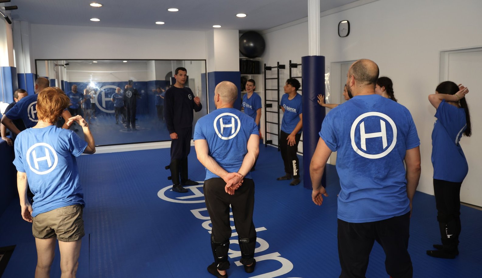 Cours de self-défense pour adultes à H Balance Studio à Strasbourg Neudorf, avec l’instructeur expliquant un exercice au groupe.