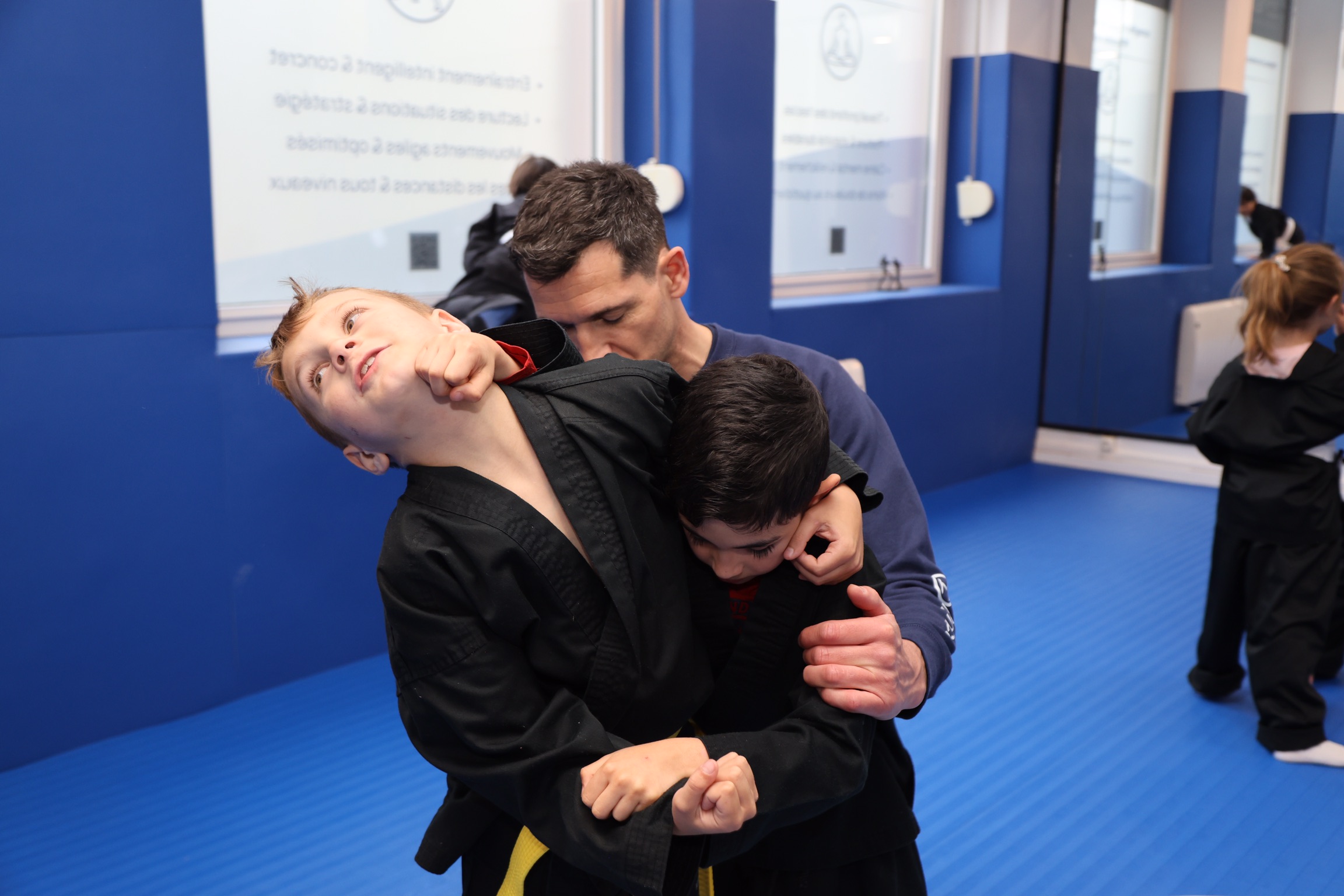 Enfants apprenant à se dégager d’une saisie au niveau du cou lors d’un cours H Balance Kung Fu Kids à Strasbourg.