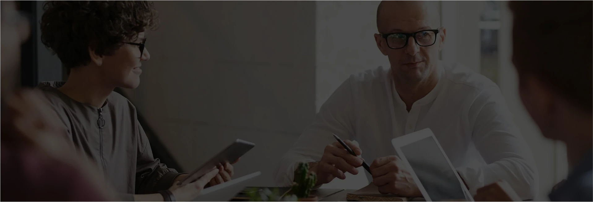Three people having a discussion at a table.