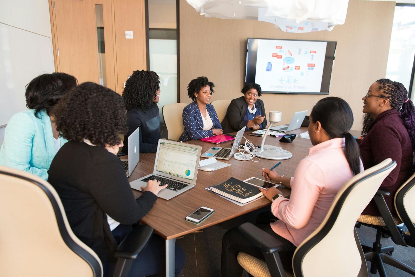 employees attend an in-person training event around a table