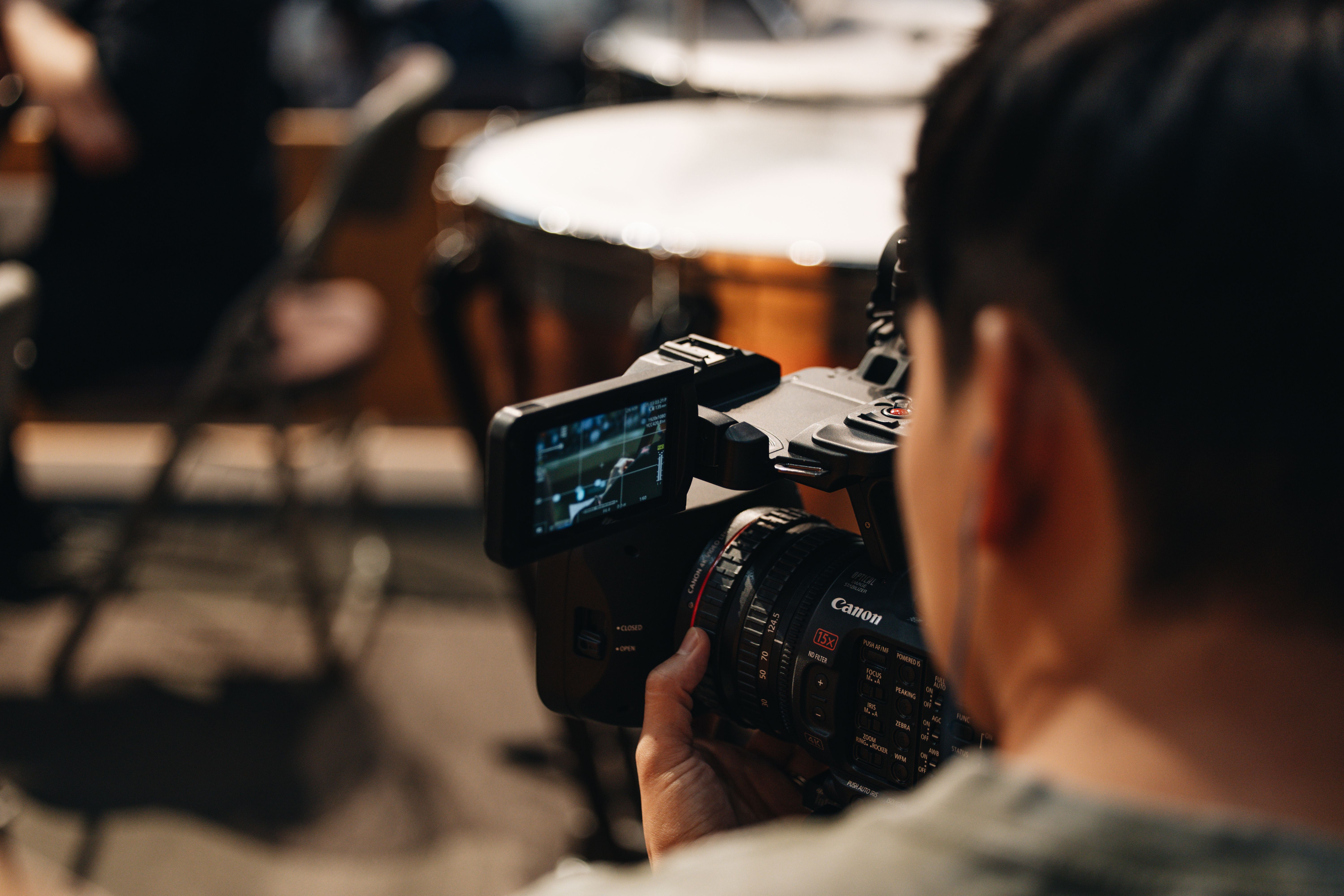 Illustrative stock photograph of a filmmaker operating a camera, photographed by Young Hwan Choi; not an AKOOL-generated result