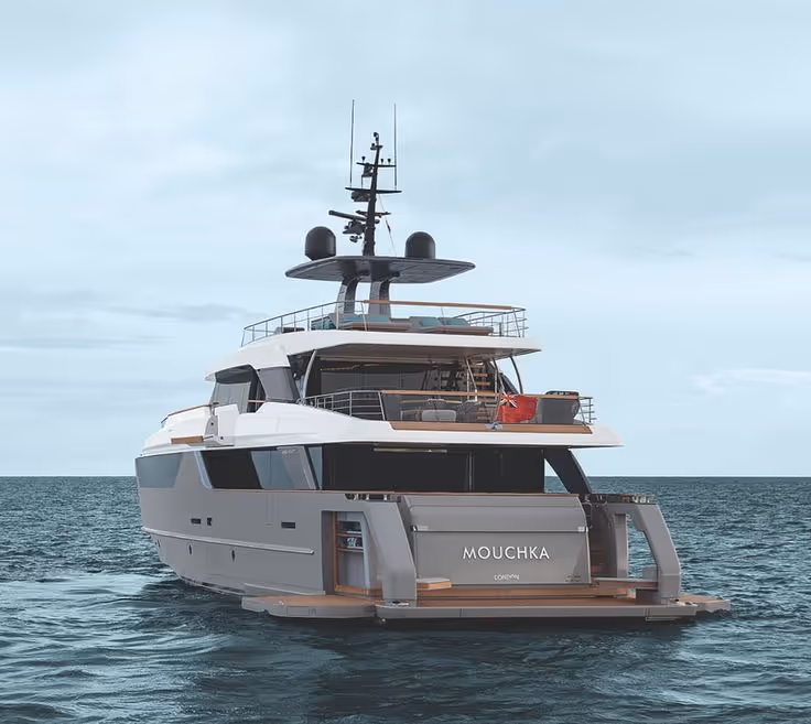Modern luxury yacht named Mouchka floating on calm sea under a cloudy sky.