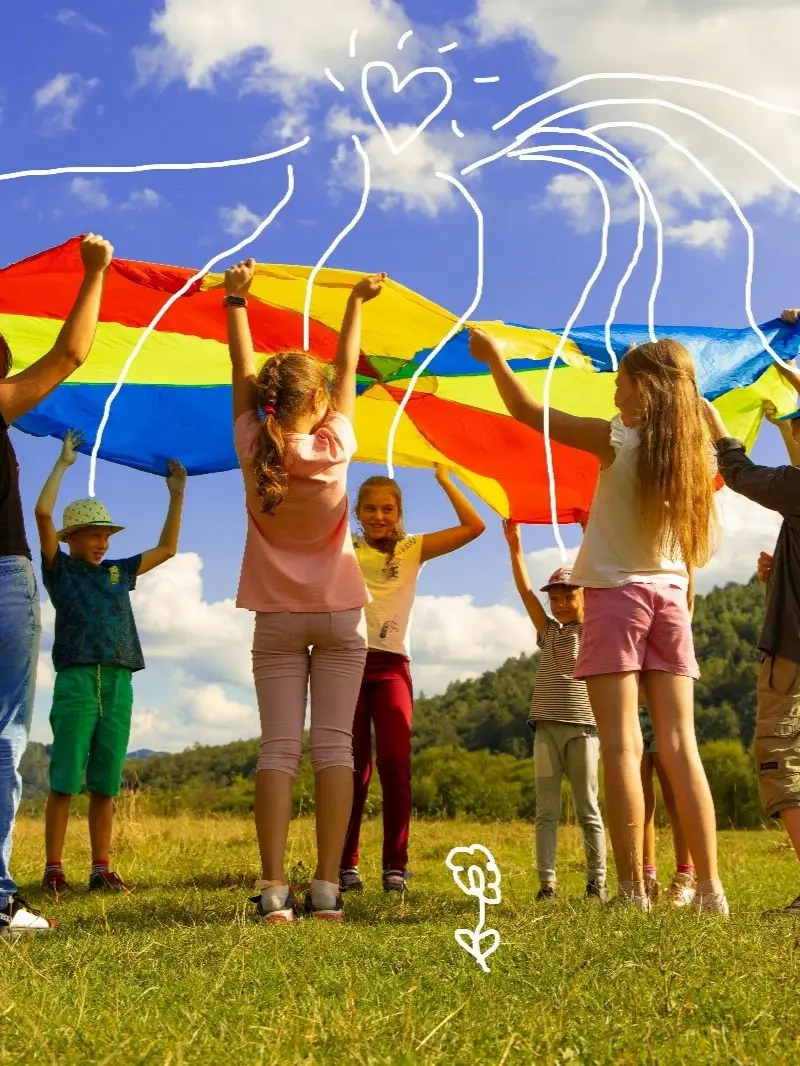 Des enfants tenant un drapeau arc en ciel