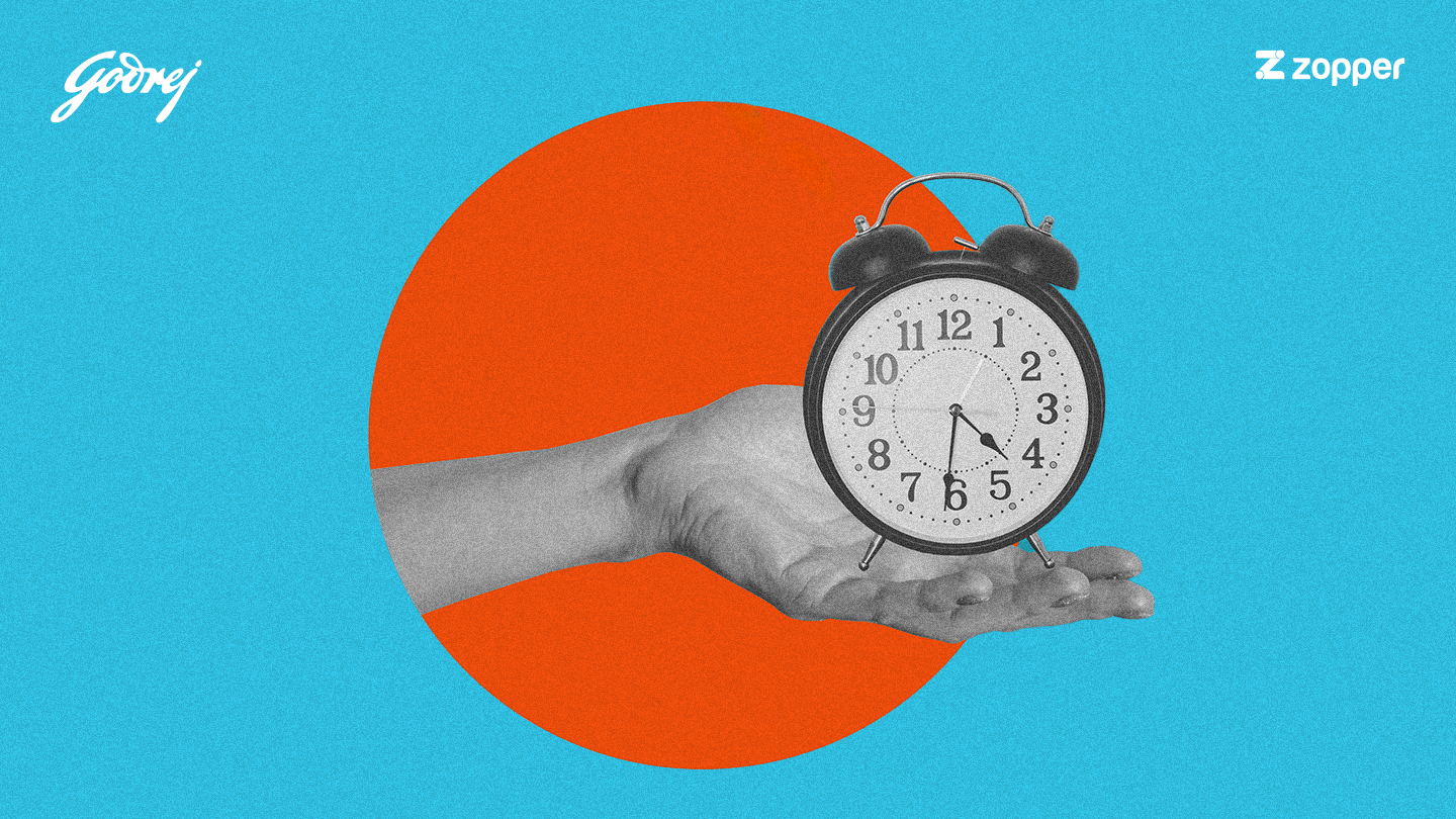 A grayscale hand holds a black and white alarm clock showing 4:30, against an orange circle on a blue background with Godrej and Zopper logos.