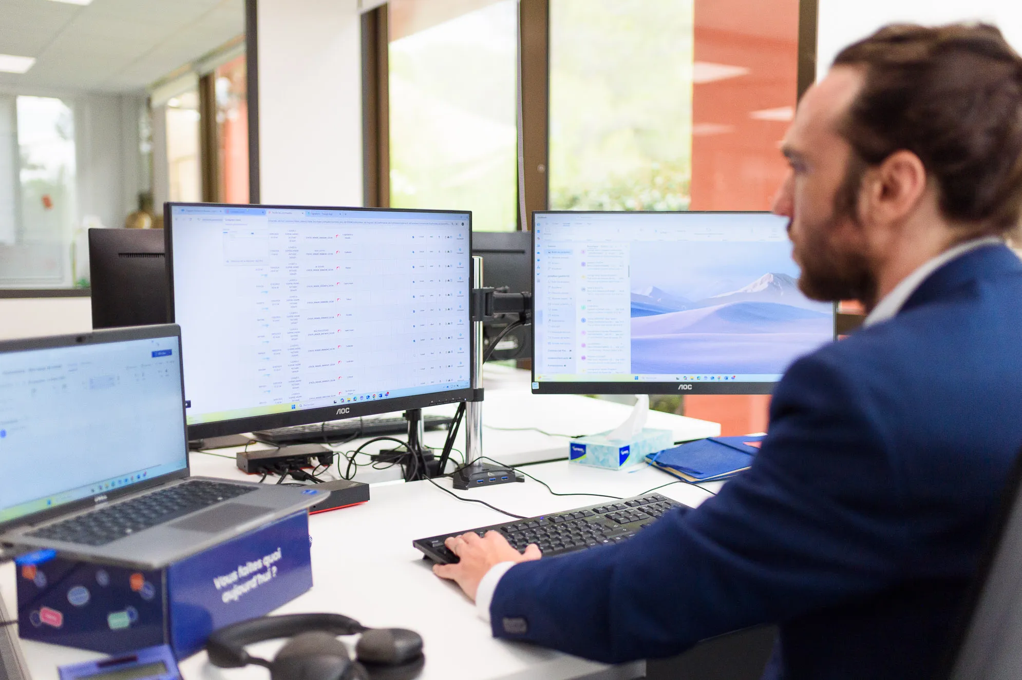 Commercial Preventimmo travaillant sur ordinateur dans un bureau moderne lumineux.