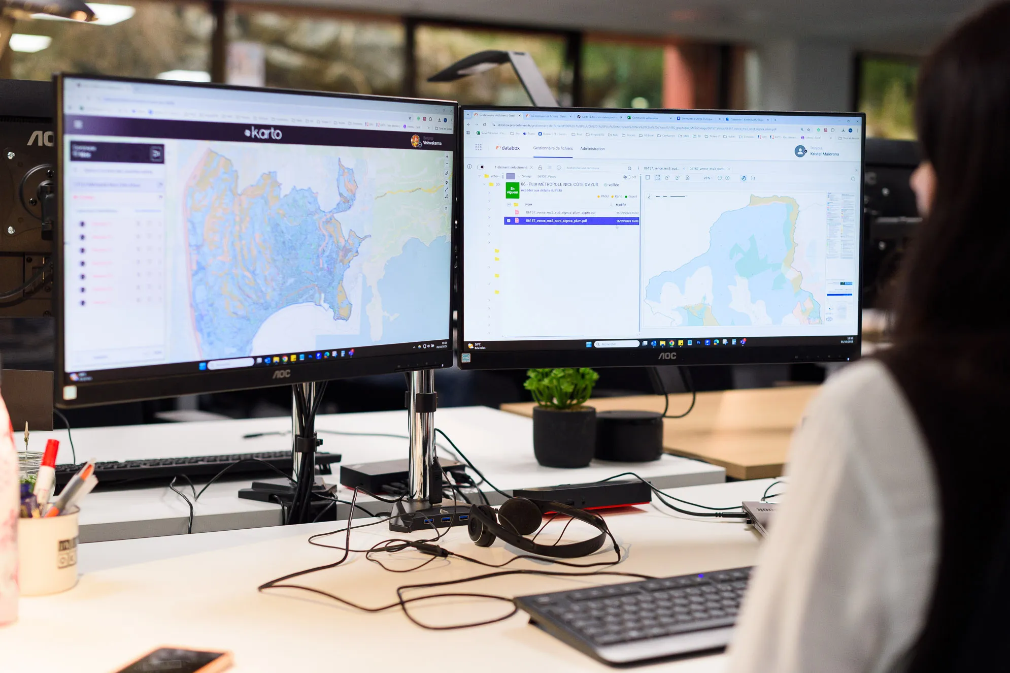 Experte Preventimmo devant un bureau avec deux écrans affichant des cartes numériques et fichiers.