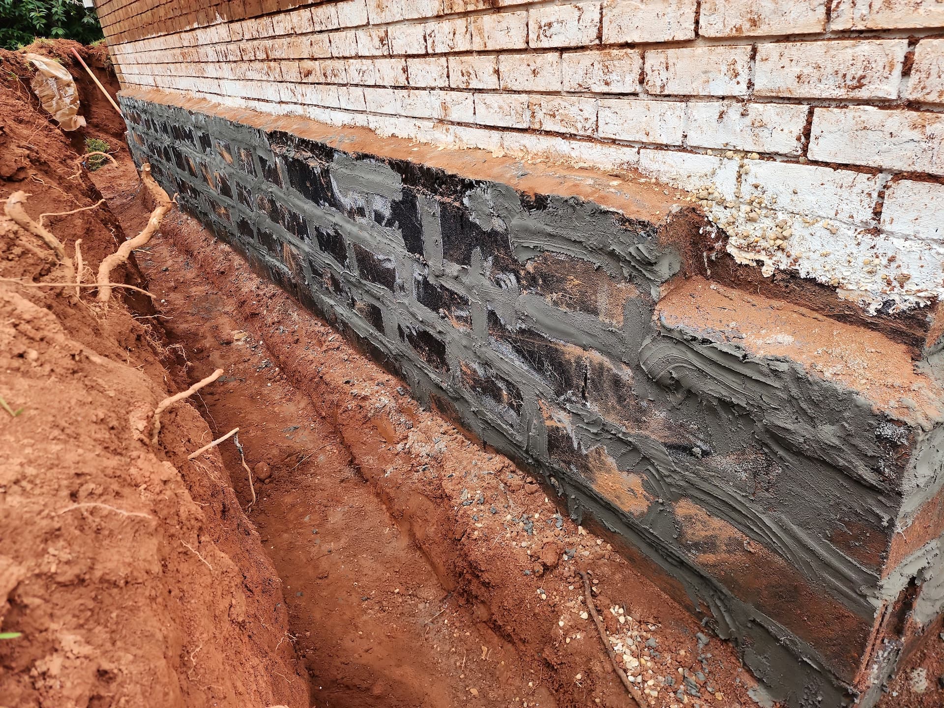 Helical piers foundation repair in progress