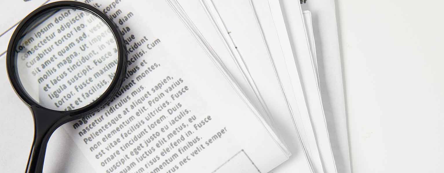 A magnifying glass over a document denoting Marsons Solicitors attention to detail.