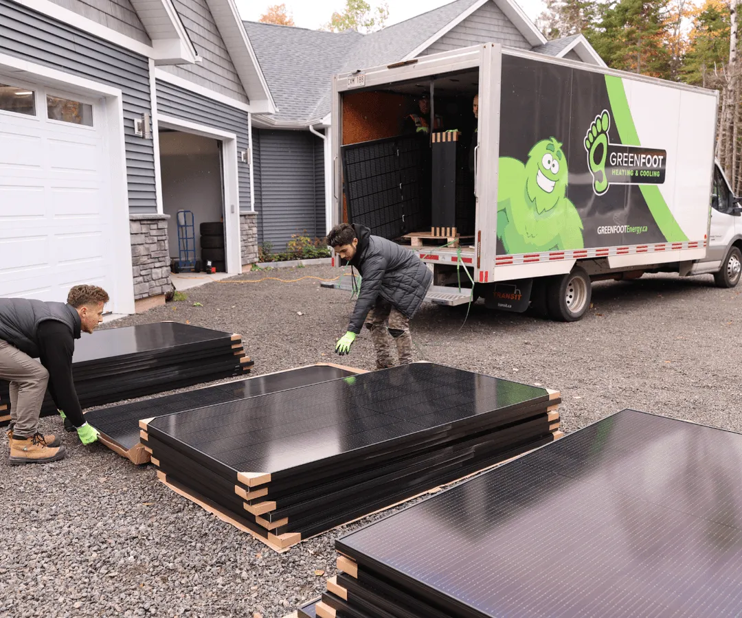 a group of men loading solar panels