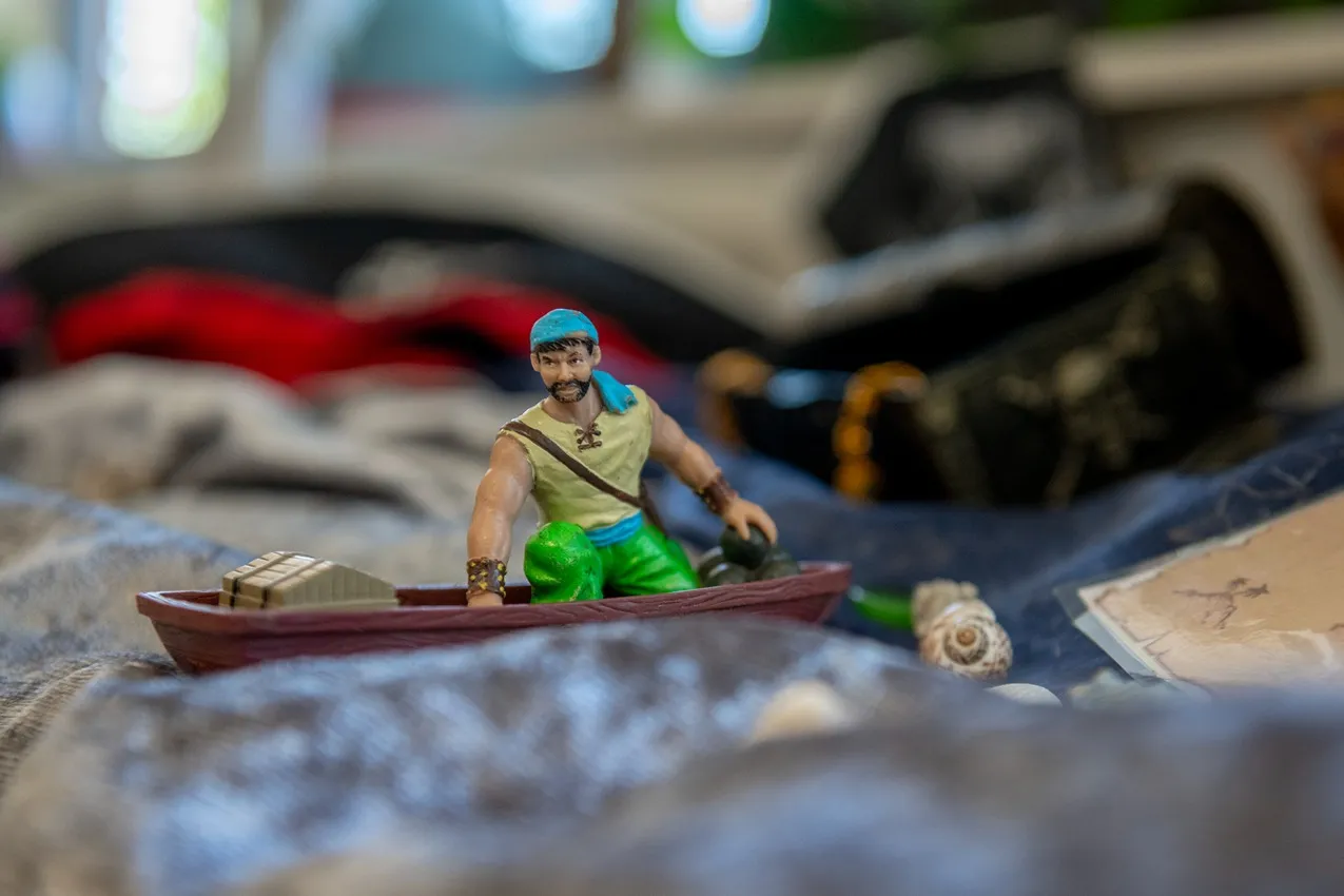 Toy pirate figurine in a boat with treasure. Imaginative play for kids' nursery decor.