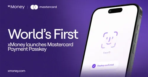 xMoney and Mastercard co-branded banner announcing "World's First: xMoney launches Mastercard Payment Passkey." Features a smartphone displaying a Face ID biometric authentication screen with a "Passkey confirmed" confirmation message, set against a purple